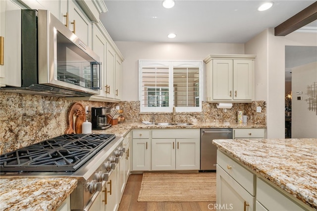 14131 Apple Grove Ct, Eastvale, CA 92880 - kitchen with stainless steel appliances, light wood-type flooring, recessed lighting, light stone counters, and backsplash