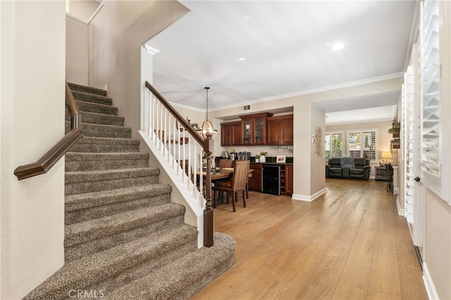 14131 Apple Grove Ct, Eastvale, CA 92880 - stairway featuring hardwood / wood-style floors, wine cooler, crown molding, a chandelier, and recessed lighting