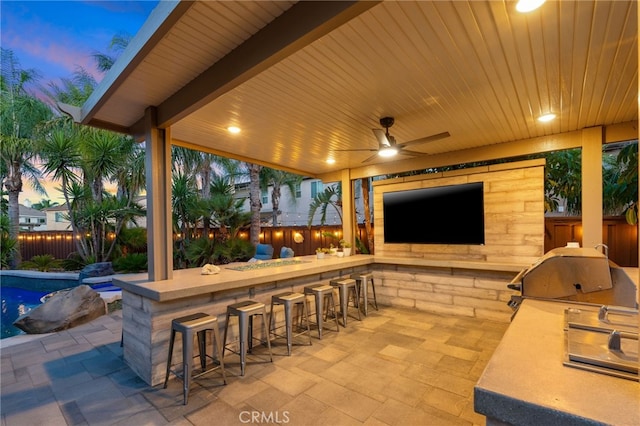 14131 Apple Grove Ct, Eastvale, CA 92880 - patio terrace at dusk featuring a fenced backyard, exterior kitchen, and a patio
