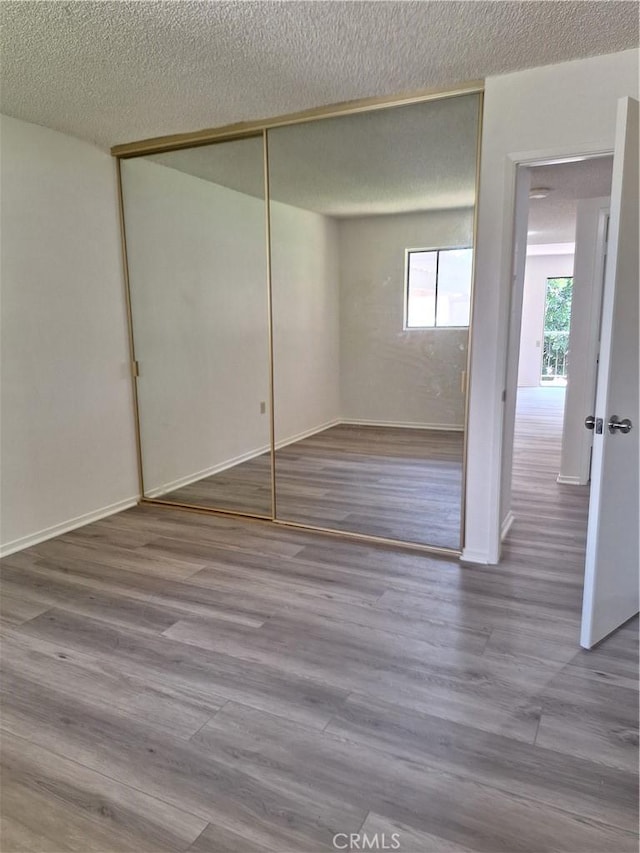 3144 Via Vis Unit Q, Laguna Woods, CA 92637 - unfurnished bedroom with a closet, wood finished floors, and a textured ceiling