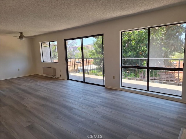 3144 Via Vis Unit Q, Laguna Woods, CA 92637 - spare room with a textured ceiling, wood finished floors, ceiling fan, and a wall mounted AC