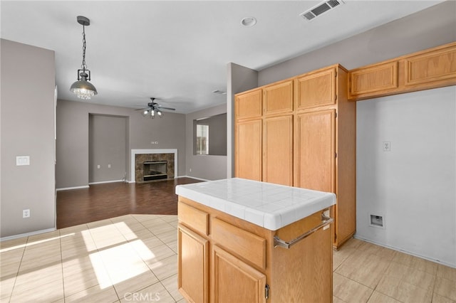 11890 Greenbluff Way, Yucaipa, CA 92399 - kitchen with tile counters, ceiling fan, light tile patterned floors, and a tile fireplace