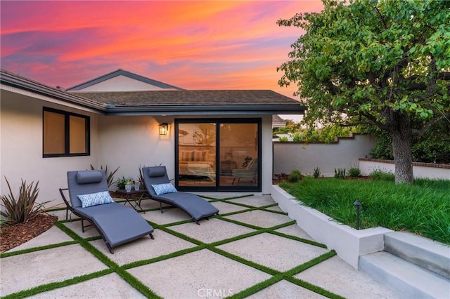 35 Beachcomber Dr, Corona Del Mar, CA 92625 - back of house at dusk with stucco siding and a patio area