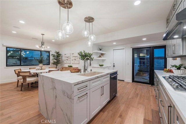 35 Beachcomber Dr, Corona Del Mar, CA 92625 - kitchen with under cabinet range hood, appliances with stainless steel finishes, a kitchen island with sink, light wood finished floors, and light stone countertops