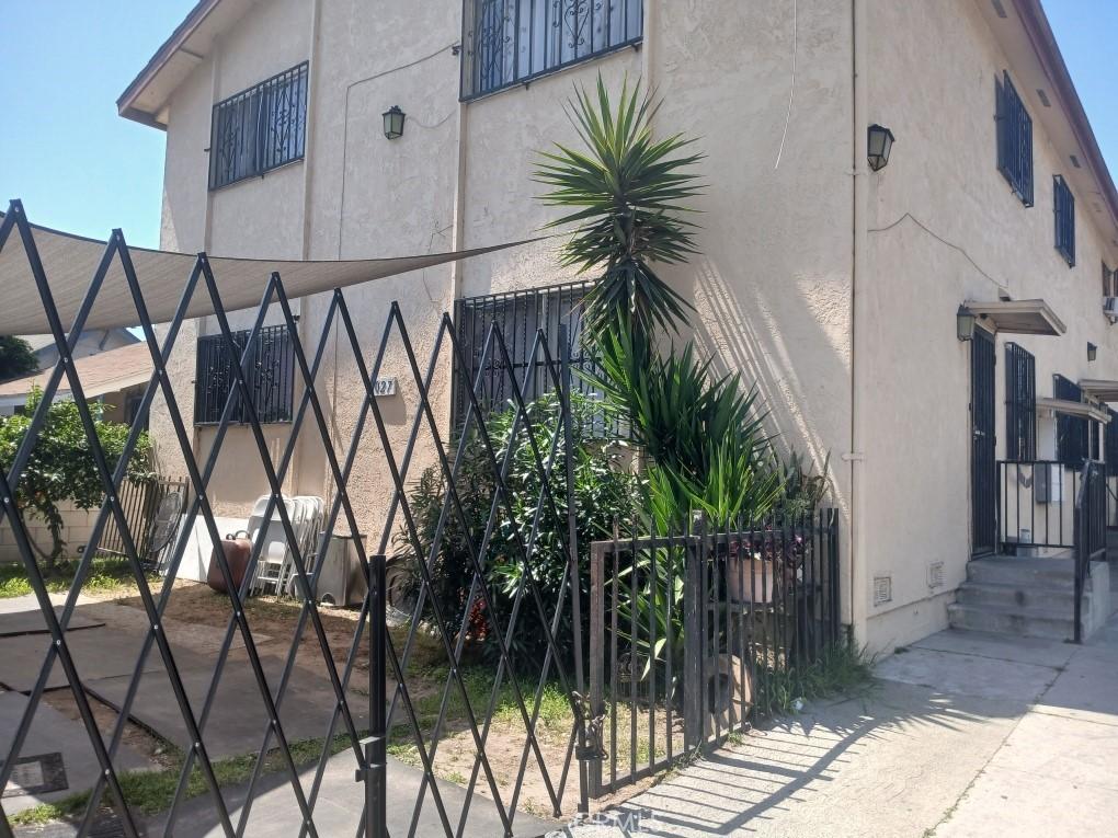 6027 Makee Ave, Los Angeles, CA 90001 - view of home's exterior with stucco siding, a gate, and crawl space
