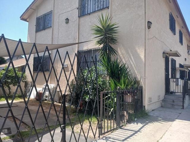 6027 Makee Ave, Los Angeles, CA 90001 - view of home's exterior with stucco siding, a gate, and crawl space