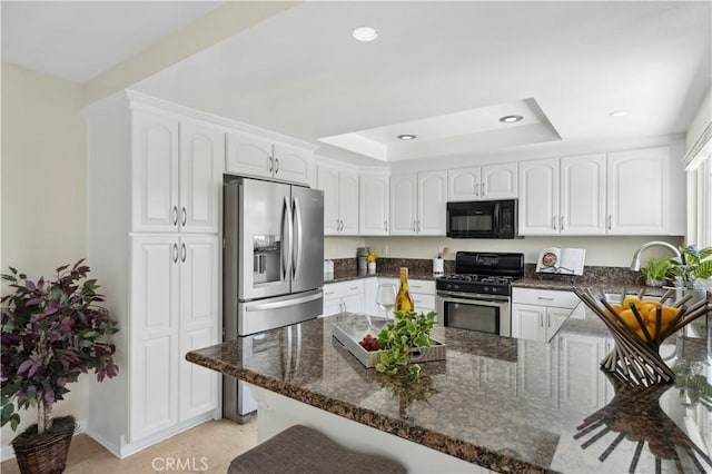 18643 Las Flores St, Fountain Valley, CA 92708 - kitchen featuring appliances with stainless steel finishes, a peninsula, recessed lighting, dark stone countertops, and white cabinetry