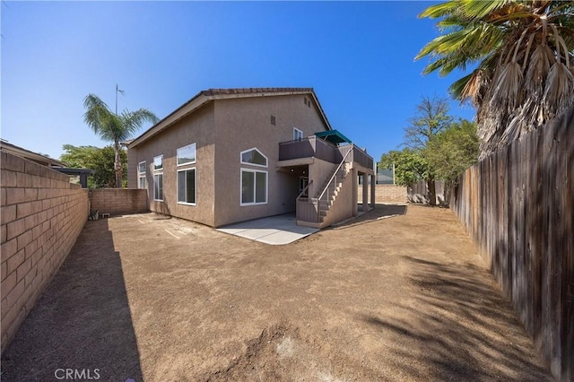 40132 White Leaf Ln, Murrieta, CA 92562 - back of property with a fenced backyard, stairway, stucco siding, and a patio area