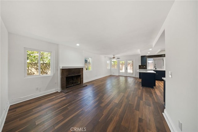 40132 White Leaf Ln, Murrieta, CA 92562 - unfurnished living room with dark wood-type flooring, a brick fireplace, recessed lighting, french doors, and ceiling fan