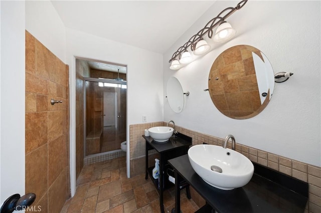 40132 White Leaf Ln, Murrieta, CA 92562 - bathroom with a stall shower, stone tile flooring, tile walls, two vanities, and wainscoting