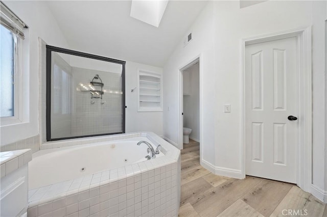 40132 White Leaf Ln, Murrieta, CA 92562 - bathroom with a whirlpool tub, wood finished floors, vaulted ceiling, a skylight, and vanity