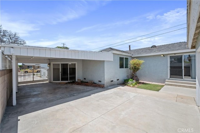 513 W D St, Wilmington, CA 90744 - back of property with crawl space, a carport, entry steps, stucco siding, and concrete driveway