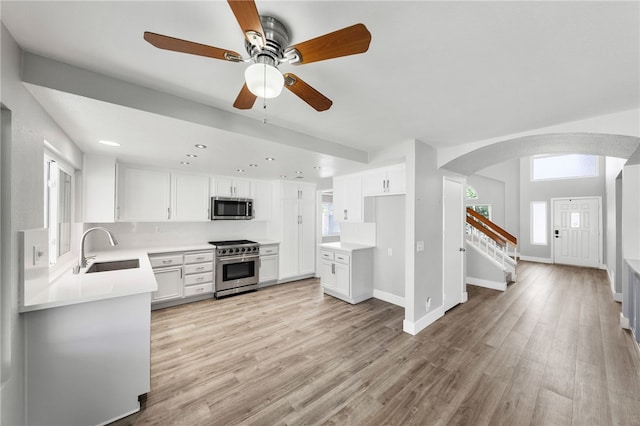 7250 Goldboro Ln, Riverside, CA 92506 - kitchen with appliances with stainless steel finishes, arched walkways, ceiling fan, light wood-type flooring, and recessed lighting