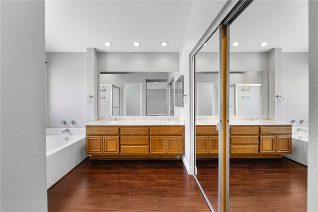 7250 Goldboro Ln, Riverside, CA 92506 - full bathroom with double vanity, a bath, wood finished floors, a stall shower, and recessed lighting