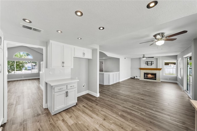 7250 Goldboro Ln, Riverside, CA 92506 - unfurnished living room with a ceiling fan, light wood-style floors, a fireplace, recessed lighting, and a textured ceiling