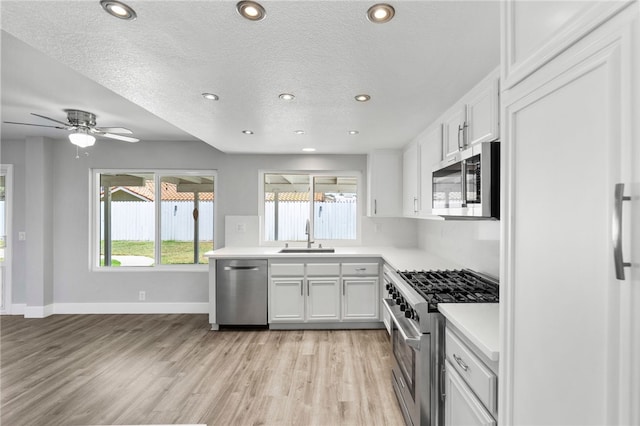 7250 Goldboro Ln, Riverside, CA 92506 - kitchen featuring premium appliances, light wood finished floors, light countertops, white cabinetry, and recessed lighting