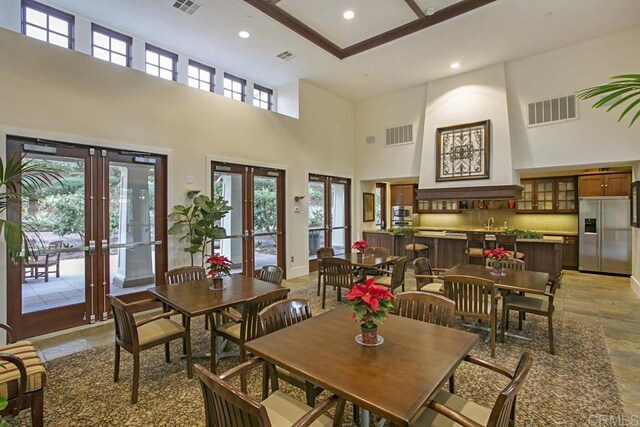 7603 Circulo Sequoia, Carlsbad, CA 92009 - dining area with french doors, a high ceiling, recessed lighting, and light stone finish flooring