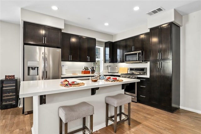 911 Santa Fe Ave Unit A, San Gabriel, CA 91776 - kitchen featuring appliances with stainless steel finishes, wine cooler, a kitchen breakfast bar, light wood-style flooring, and recessed lighting