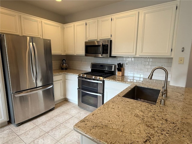 21 Veneto Ln, Aliso Viejo, CA 92656 - kitchen featuring appliances with stainless steel finishes, light stone countertops, tasteful backsplash, and light tile patterned flooring