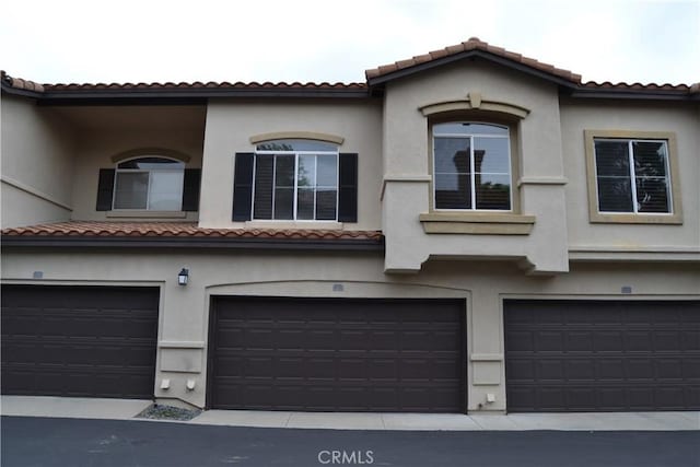 21 Veneto Ln, Aliso Viejo, CA 92656 - view of front of house featuring an attached garage, stucco siding, and a tiled roof