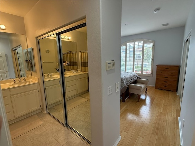 21 Veneto Ln, Aliso Viejo, CA 92656 - bathroom featuring two vanities and wood finished floors