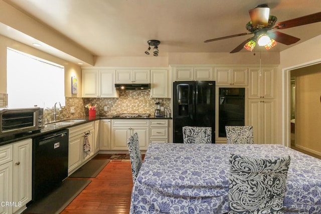 3036 Fairesta St, La Crescenta, CA 91214 - kitchen with black appliances, under cabinet range hood, a ceiling fan, dark wood-type flooring, and backsplash