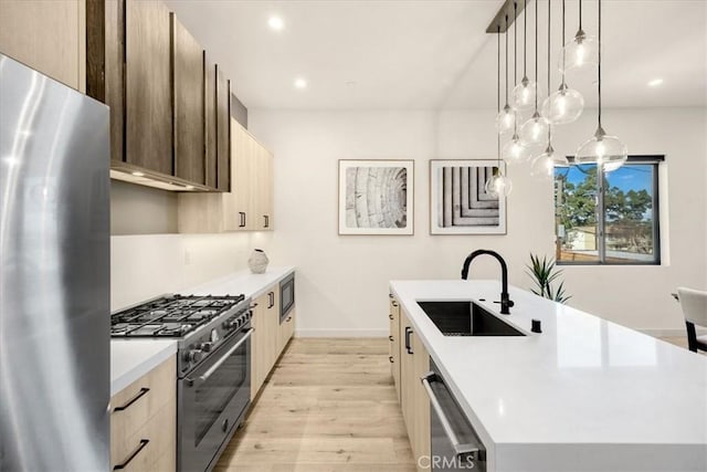 756 W 19th St Unit B, Costa Mesa, CA 92627 - kitchen featuring appliances with stainless steel finishes, modern cabinets, an island with sink, light wood-type flooring, and light countertops