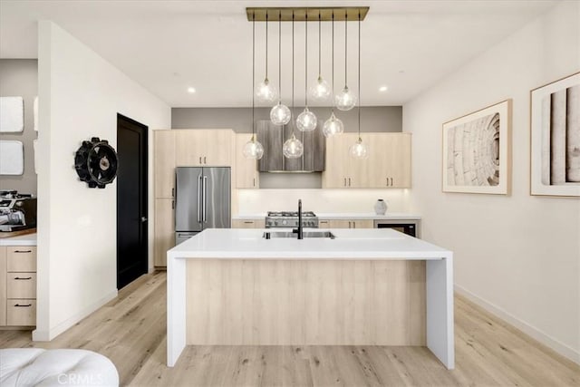 756 W 19th St Unit B, Costa Mesa, CA 92627 - kitchen with high quality fridge, light brown cabinetry, light wood finished floors, a center island with sink, and light countertops