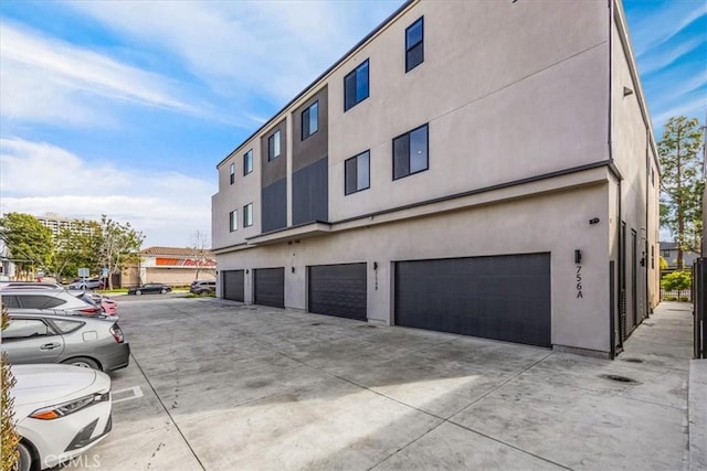 756 W 19th St Unit B, Costa Mesa, CA 92627 - view of property exterior with driveway, an attached garage, and stucco siding
