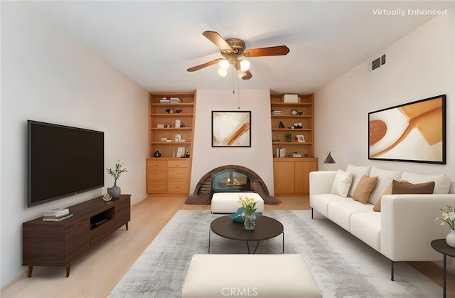 2747 Persimmon Pl, Riverside, CA 92506 - living area featuring ceiling fan, light wood-style floors, built in features, and a glass covered fireplace