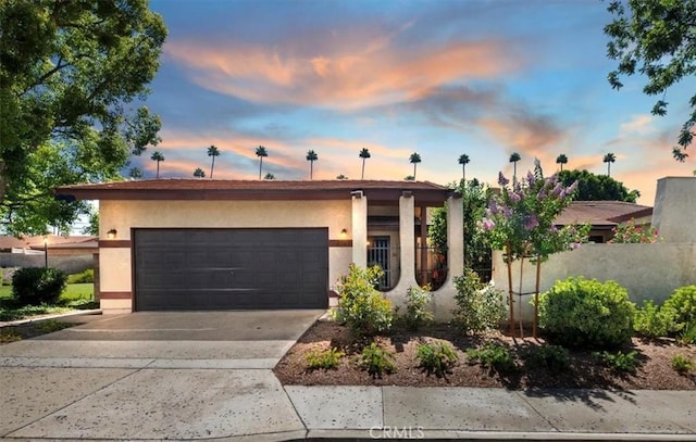 2747 Persimmon Pl, Riverside, CA 92506 - view of front facade with an attached garage, concrete driveway, and stucco siding