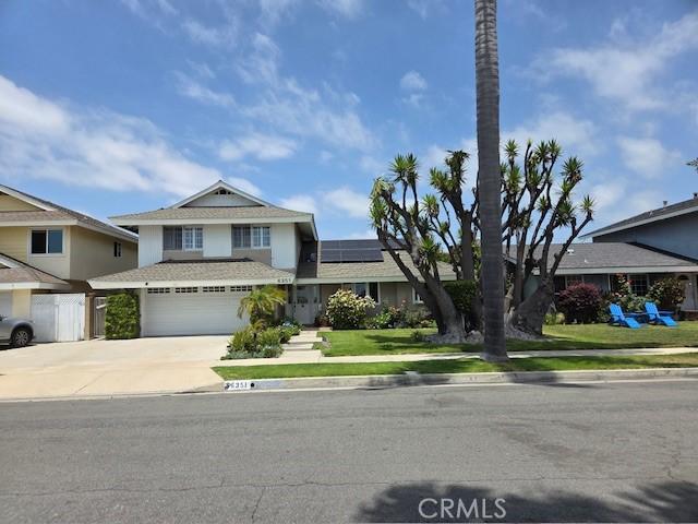 6351 Gloria Dr, Huntington Beach, CA 92647 - traditional-style home with driveway, solar panels, an attached garage, and a front yard