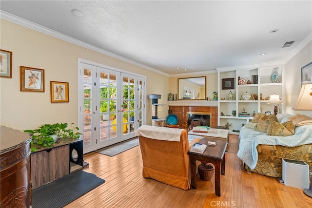 6351 Gloria Dr, Huntington Beach, CA 92647 - living room with crown molding, wood-type flooring, french doors, and a tiled fireplace