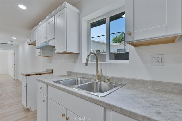 156 N Sunset Ave, Banning, CA 92220 - kitchen featuring recessed lighting, white cabinetry, light wood-style floors, under cabinet range hood, and light countertops