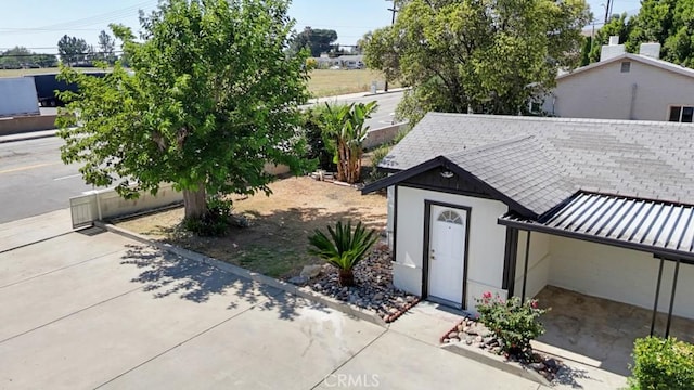 156 N Sunset Ave, Banning, CA 92220 - view of side of home featuring a standing seam roof, roof with shingles, and a metal roof
