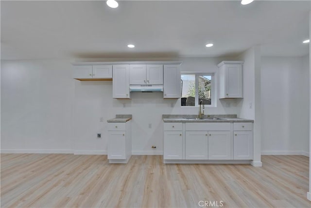 156 N Sunset Ave, Banning, CA 92220 - kitchen featuring light wood finished floors, white cabinets, under cabinet range hood, and recessed lighting