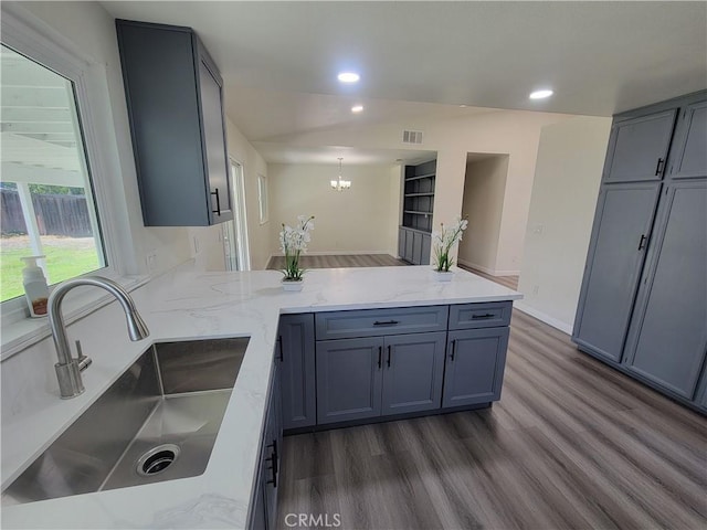 12922 Glenmere Dr, Moreno Valley, CA 92553 - kitchen featuring a peninsula, recessed lighting, dark wood-type flooring, light stone countertops, and a chandelier