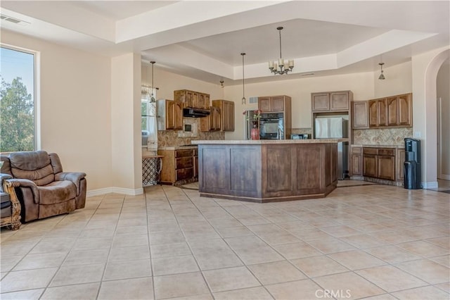 11110 Choctaw Dr, Bakersfield, CA 93308 - kitchen with a tray ceiling, light tile patterned flooring, stainless steel refrigerator, black oven, and open floor plan