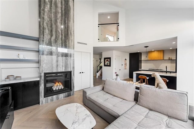 45 Morena, Irvine, CA 92612 - living area featuring a towering ceiling, stairway, a large fireplace, and recessed lighting