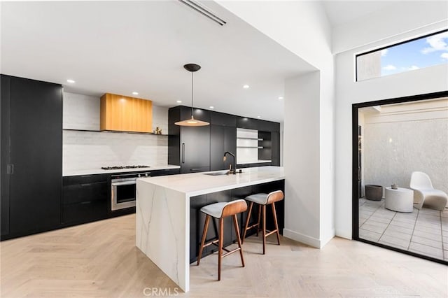 45 Morena, Irvine, CA 92612 - kitchen featuring oven, modern cabinets, dark cabinets, a breakfast bar, and a peninsula