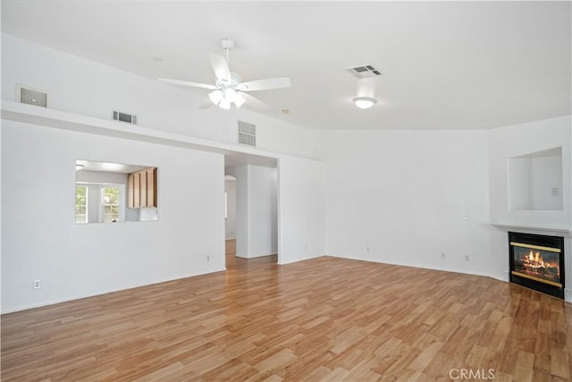 43733 6th St E, Lancaster, CA 93535 - unfurnished living room with ceiling fan, a glass covered fireplace, and light wood finished floors