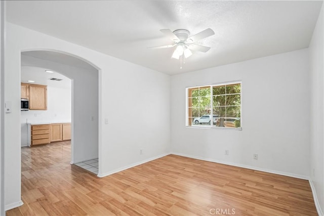 43733 6th St E, Lancaster, CA 93535 - spare room with ceiling fan, light wood finished floors, and arched walkways