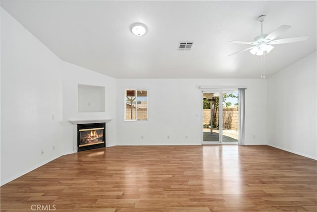 43733 6th St E, Lancaster, CA 93535 - unfurnished living room featuring ceiling fan, vaulted ceiling, light wood finished floors, and a glass covered fireplace