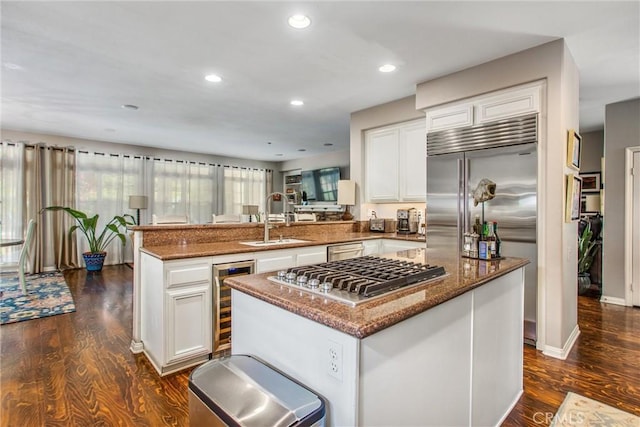 512 Golden W Dr, Redlands, CA 92373 - kitchen featuring appliances with stainless steel finishes, wine cooler, a peninsula, dark stone counters, and dark wood-style floors
