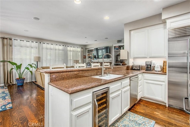 512 Golden W Dr, Redlands, CA 92373 - kitchen featuring appliances with stainless steel finishes, wine cooler, a peninsula, open floor plan, and white cabinetry