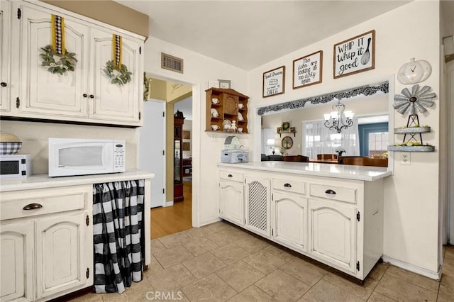 15902 Santa Fe St, Whittier, CA 90603 - kitchen with white microwave, a chandelier, light countertops, and a peninsula