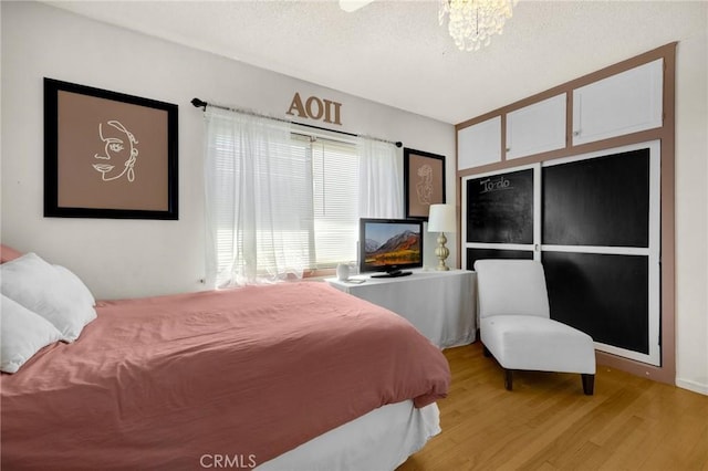 15902 Santa Fe St, Whittier, CA 90603 - bedroom with light wood-style floors, a textured ceiling, and a chandelier