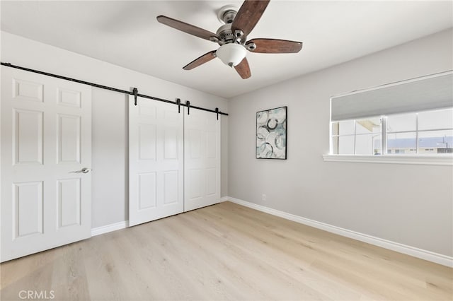 19615 E Tudor St, Covina, CA 91724 - unfurnished bedroom featuring wood finished floors, a barn door, a closet, and ceiling fan