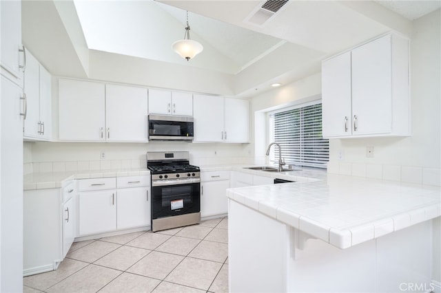 11500 Winery Dr, Fontana, CA 92337 - kitchen with appliances with stainless steel finishes, a peninsula, white cabinetry, tile countertops, and pendant lighting