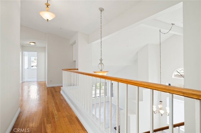 11500 Winery Dr, Fontana, CA 92337 - hallway with lofted ceiling, wood-type flooring, and a chandelier